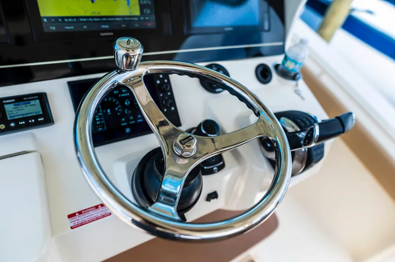  Yacht Photos Pics Steering wheel of 2019 Scout 355 LXF boat with modern controls and navigation display.