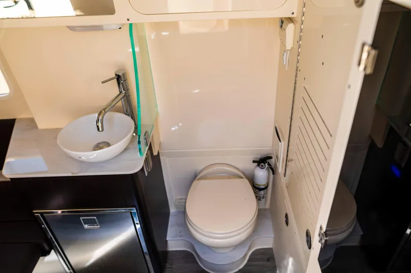  Yacht Photos Pics 2019 Scout 355 LXF boat bathroom with sink, toilet, and storage cabinet.