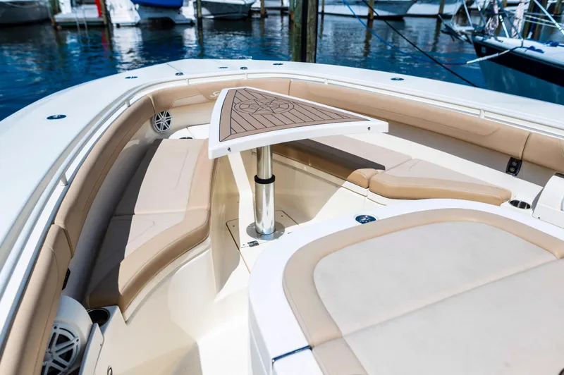  Yacht Photos Pics 2019 Scout 355 LXF boat interior with cushioned seating and table, docked at marina.