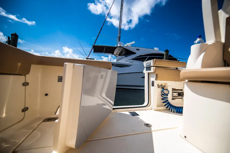  Yacht Photos Pics 2019 Scout 355 LXF boat interior with open hatch, blue sky, and docked yacht.