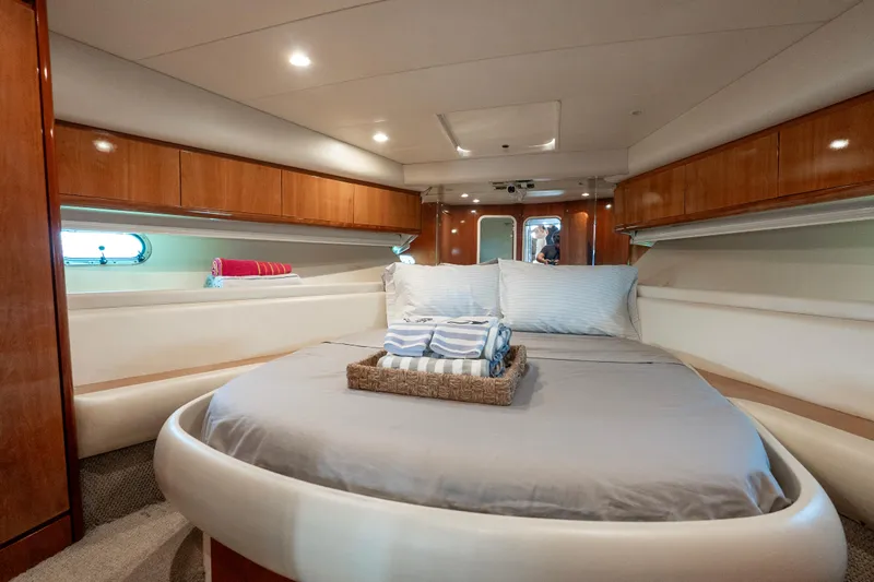  Yacht Photos Pics Luxurious cabin interior of 1998 Azimut 43 Fly yacht with cozy bed and elegant wood finish.