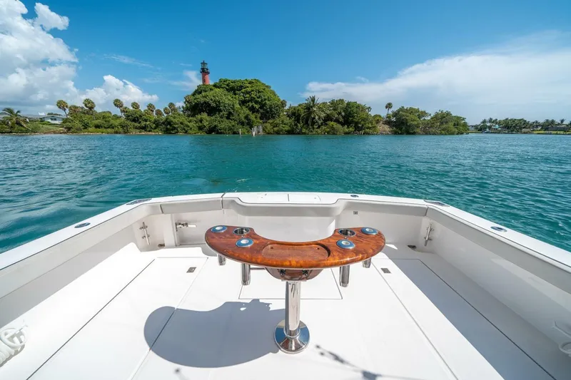 Big Hit Yacht Photos Pics 2020 Cabo 40 Express boat with scenic lighthouse view on calm waters.