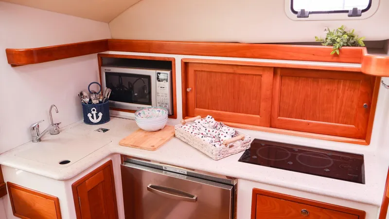 4709tw Yacht Photos Pics 2010 MJM 40z Downeast yacht kitchen with microwave, stove, and wooden cabinets.