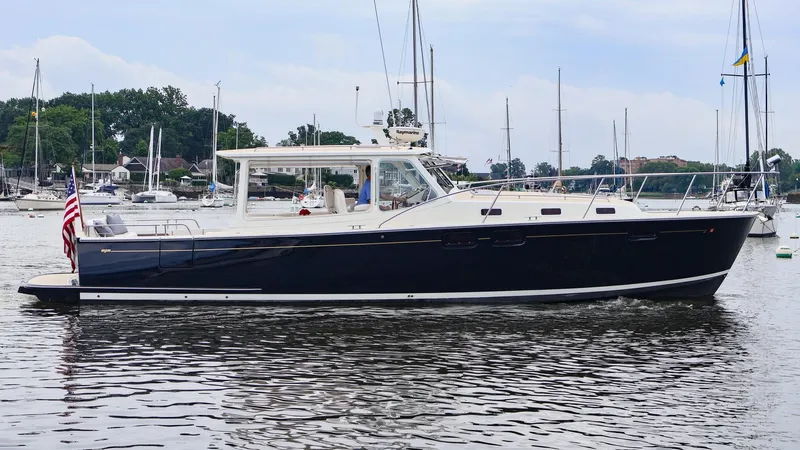 4709tw Yacht Photos Pics 2010 MJM 40z Downeast boat cruising in a marina with sailboats in the background.