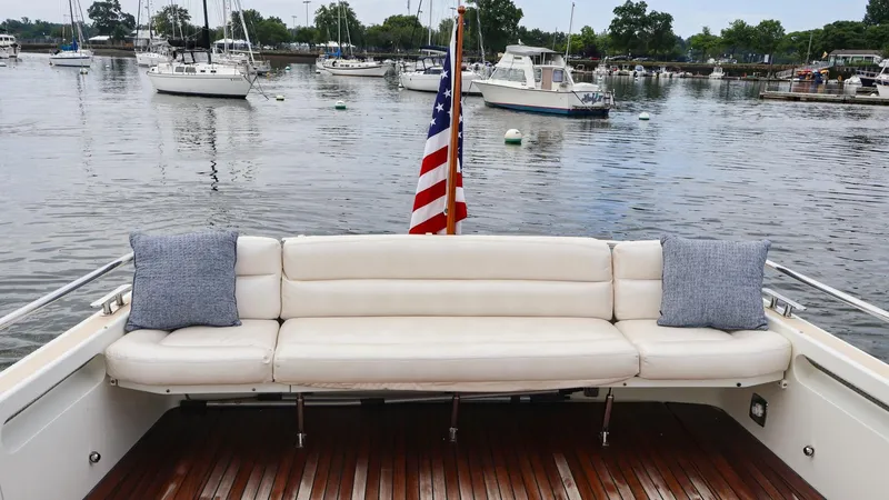 4709tw Yacht Photos Pics 2010 MJM 40z Downeast boat with white seating and American flag in a marina.