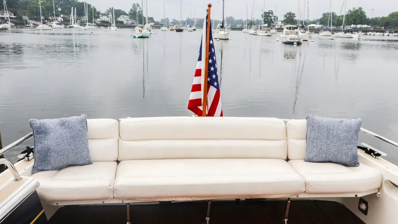 4709tw Yacht Photos Pics 2010 MJM 40z Downeast boat with white seating and American flag on calm water.