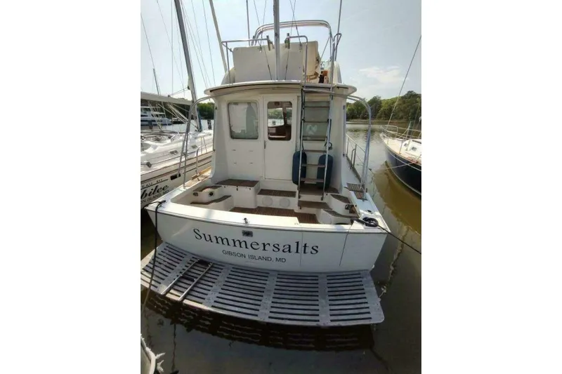Summersalts Yacht Photos Pics 1996 Grand Banks Eastbay 40 Flybridge docked, rear view with "Summersalts" name visible.