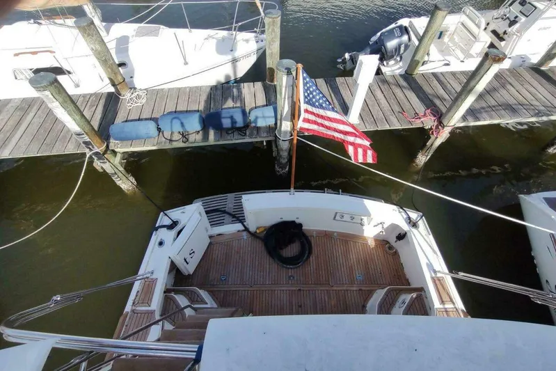 Summersalts Yacht Photos Pics 1996 Grand Banks Eastbay 40 Flybridge docked with American flag, wooden deck view.