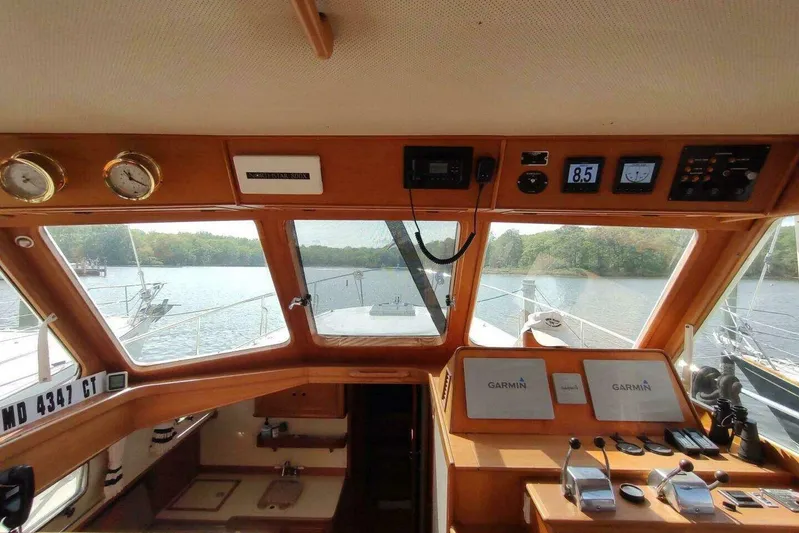 Summersalts Yacht Photos Pics 1996 Grand Banks Eastbay 40 Flybridge helm with Garmin navigation, overlooking serene waters.