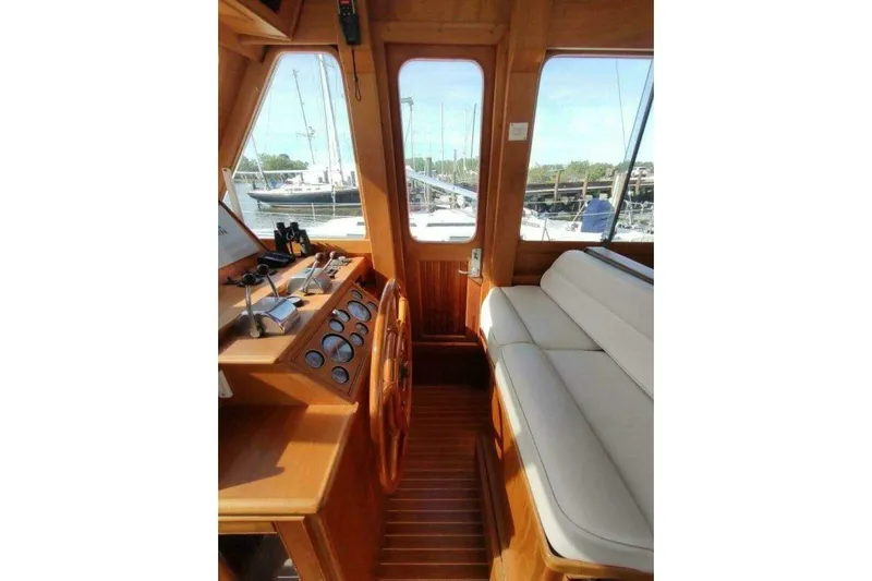 Summersalts Yacht Photos Pics 1996 Grand Banks Eastbay 40 Flybridge interior with wooden helm and cushioned seating.