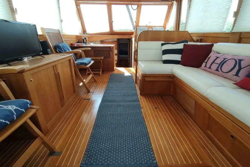 Summersalts Yacht Photos Pics Luxurious 1996 Grand Banks Eastbay 40 Flybridge interior with wooden flooring and cozy seating.