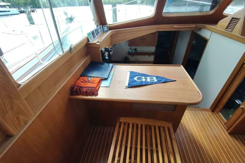 Summersalts Yacht Photos Pics Interior of 1996 Grand Banks Eastbay 40 Flybridge with wooden table and nautical decor.