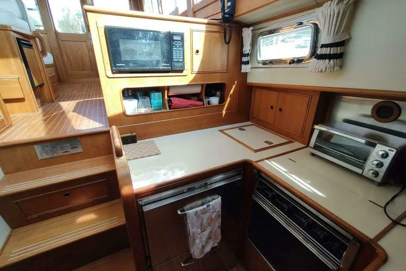 Summersalts Yacht Photos Pics 1996 Grand Banks Eastbay 40 Flybridge galley with microwave, oven, and wooden cabinetry.