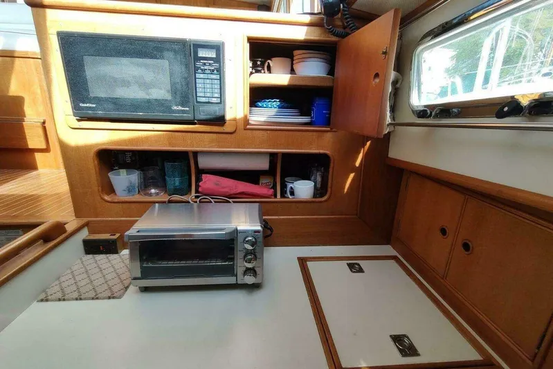 Summersalts Yacht Photos Pics 1996 Grand Banks Eastbay 40 Flybridge galley with microwave, toaster oven, and wooden cabinetry.