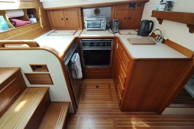 Summersalts Yacht Photos Pics 1996 Grand Banks Eastbay 40 Flybridge kitchen with wood cabinetry, stove, and appliances.