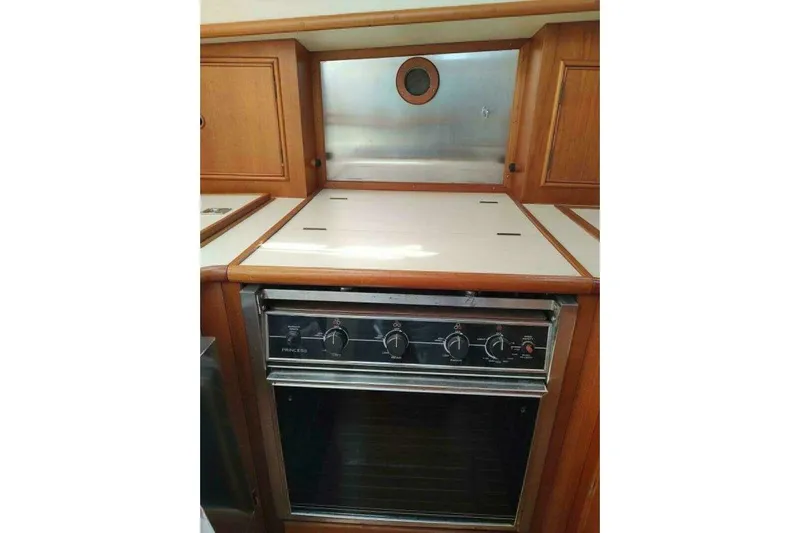 Summersalts Yacht Photos Pics 1996 Grand Banks Eastbay 40 Flybridge kitchen with stove and wooden cabinetry.
