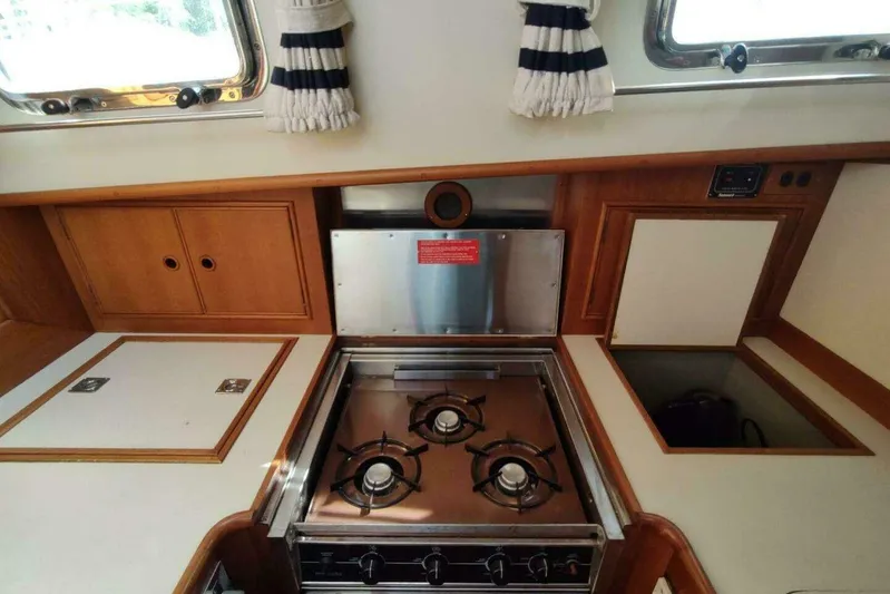 Summersalts Yacht Photos Pics Galley kitchen in 1996 Grand Banks Eastbay 40 Flybridge with gas stove and wooden cabinetry.
