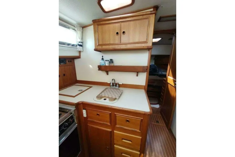 Summersalts Yacht Photos Pics 1996 Grand Banks Eastbay 40 Flybridge kitchen with wooden cabinets and countertop.
