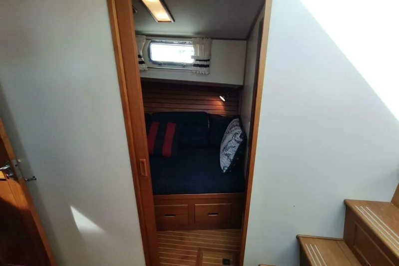 Summersalts Yacht Photos Pics Cozy cabin interior of 1996 Grand Banks Eastbay 40 Flybridge with wooden accents and bedding.
