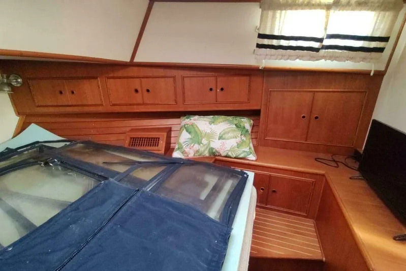 Summersalts Yacht Photos Pics 1996 Grand Banks Eastbay 40 Flybridge cabin with wooden cabinetry and tropical-themed pillow.