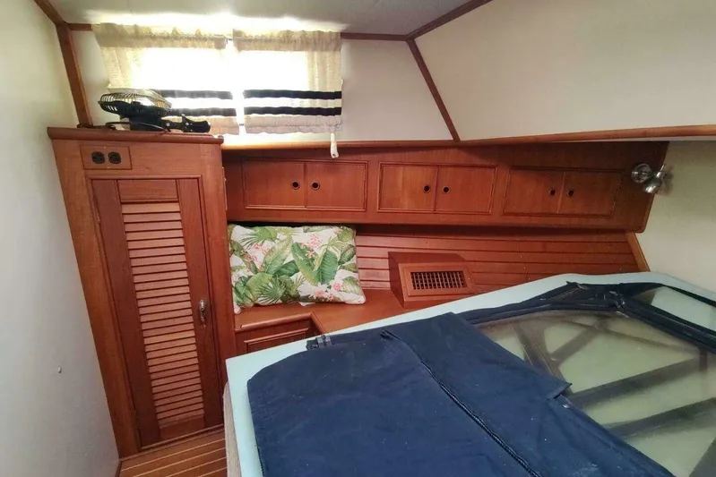 Summersalts Yacht Photos Pics 1996 Grand Banks Eastbay 40 Flybridge cabin with wooden cabinetry and tropical-themed cushion.