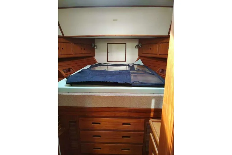 Summersalts Yacht Photos Pics 1996 Grand Banks Eastbay 40 Flybridge cabin interior with wooden cabinetry and bed.