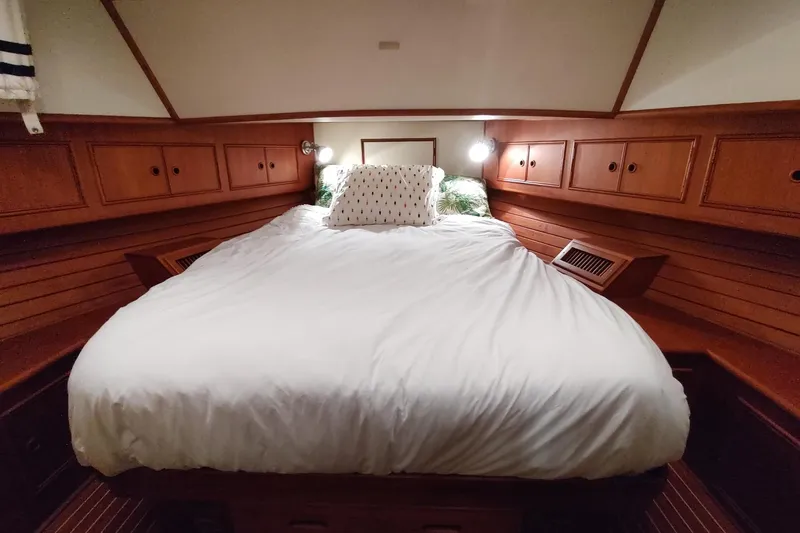 Summersalts Yacht Photos Pics Cozy cabin interior of 1996 Grand Banks Eastbay 40 Flybridge with wooden cabinetry and bed.