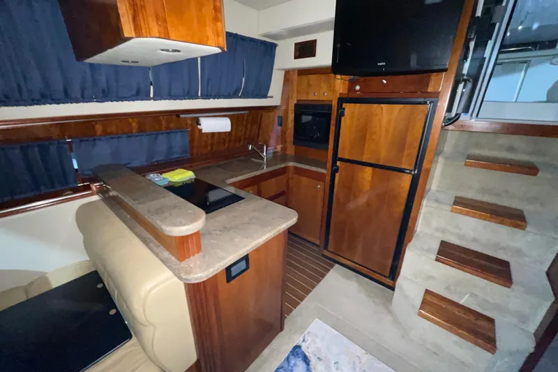  Yacht Photos Pics 2008 CRUISERS INC 415 Express Motoryacht interior with kitchen, wooden cabinetry, and stairs.