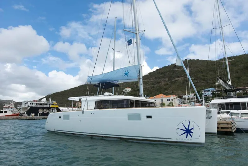  Yacht Photos Pics 2018 Lagoon 450 F catamaran docked in a marina, under a partly cloudy sky.