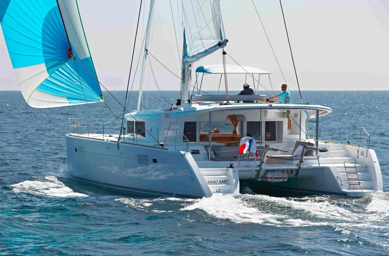  Yacht Photos Pics 2018 Lagoon 450 F catamaran sailing on open sea with vibrant blue spinnaker.