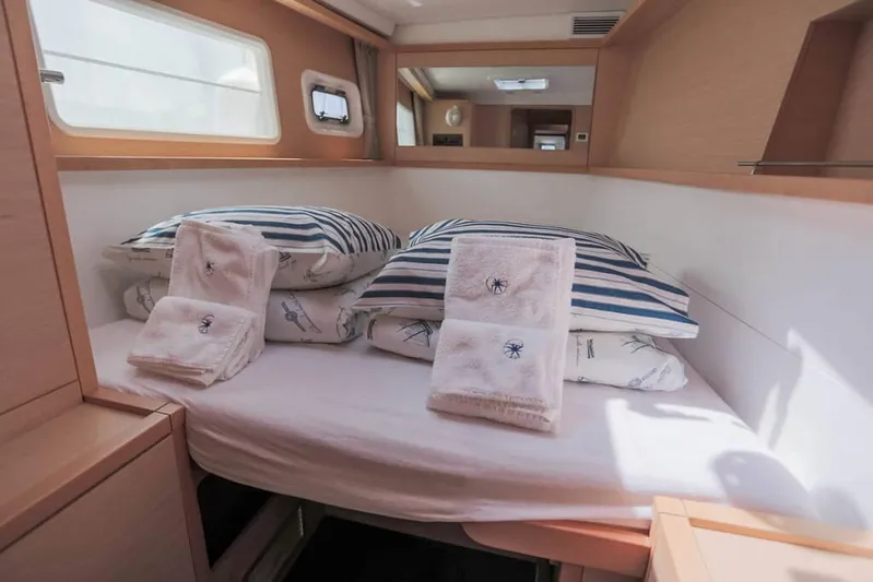  Yacht Photos Pics Cozy cabin interior of 2018 Lagoon 450 F with striped bedding and towels.