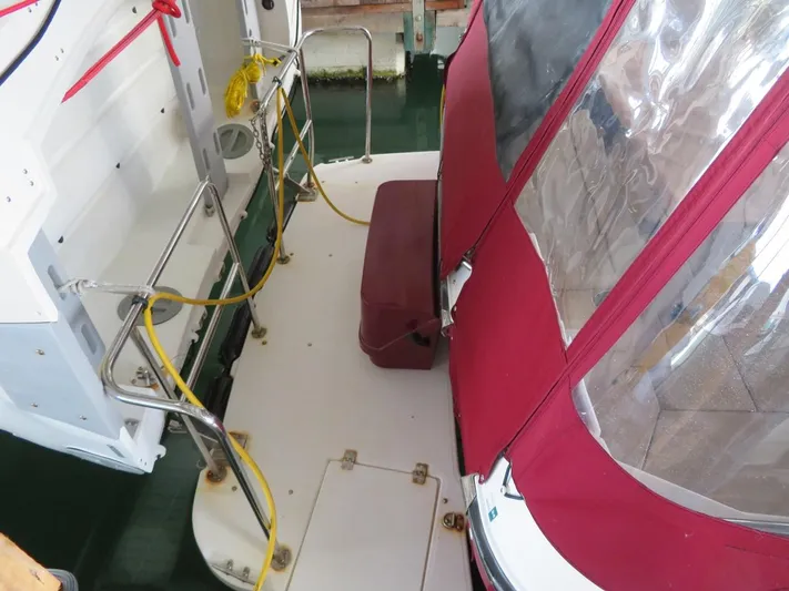 Then Again Yacht Photos Pics 2018 Ranger Tugs R-31 S boat deck with red canopy and railing.