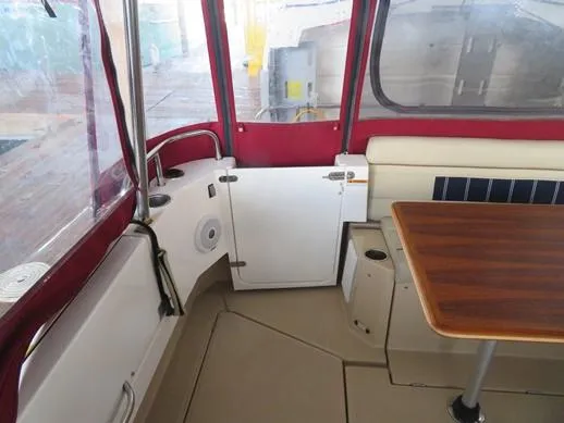 Then Again Yacht Photos Pics 2018 Ranger Tugs R-31 S interior with red accents and wooden table.