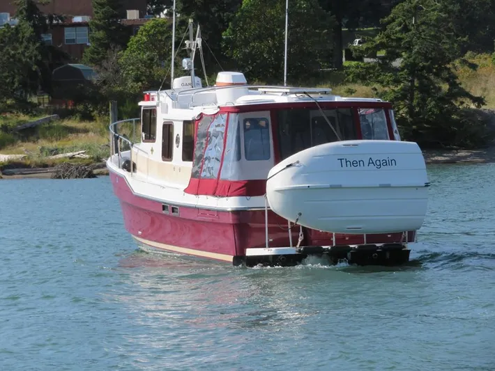 Then Again Yacht Photos Pics 2018 Ranger Tugs R-31 S boat on water, rear view, with "Then Again" on the dinghy.
