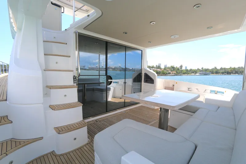 Bon Bon Yacht Photos Pics Luxurious 2020 Azimut 55 yacht deck with seating, table, and scenic waterfront view.