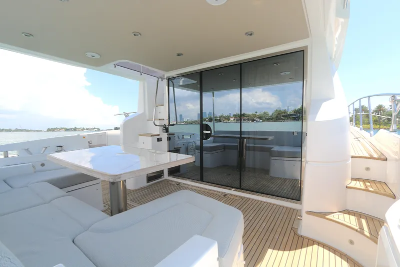 Bon Bon Yacht Photos Pics Luxurious 2020 Azimut 55 yacht deck with seating, table, and glass doors.