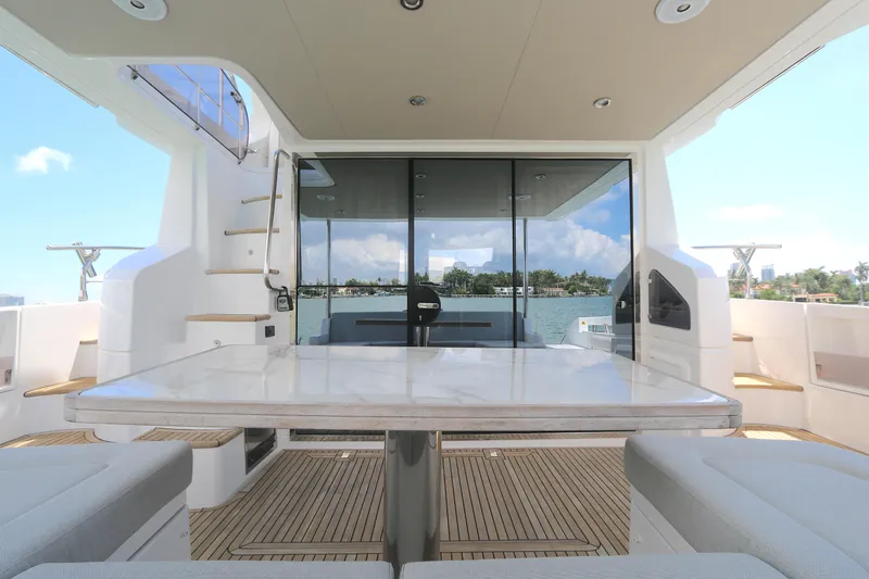 Bon Bon Yacht Photos Pics Luxury Azimut 55 yacht deck with seating and table, 2020 model, overlooking serene waters.