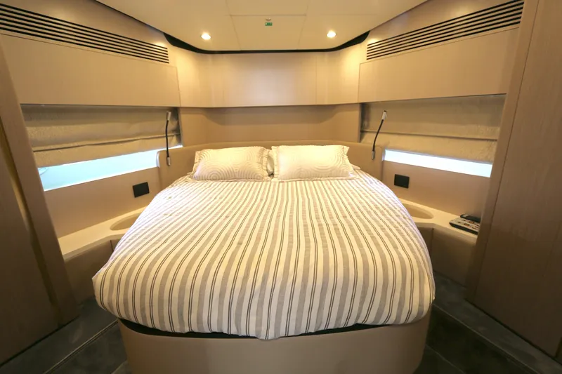 Bon Bon Yacht Photos Pics Luxurious bedroom interior of 2020 Azimut 55 yacht with striped bedding and modern design.