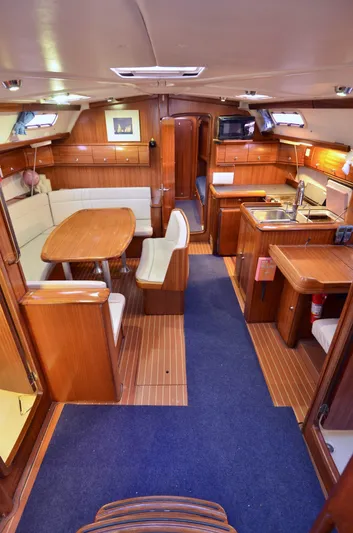 Footloose Yacht Photos Pics Interior of 2003 Bavaria 49 yacht with wooden furnishings and cozy dining area.