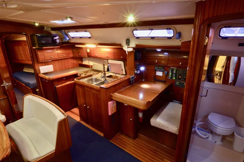 Footloose Yacht Photos Pics Luxurious interior of a 2003 Bavaria 49 yacht featuring a kitchen, dining area, and bathroom.