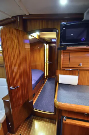 Footloose Yacht Photos Pics Interior of a 2003 Bavaria 49 yacht with wooden cabinetry and cozy sleeping quarters.