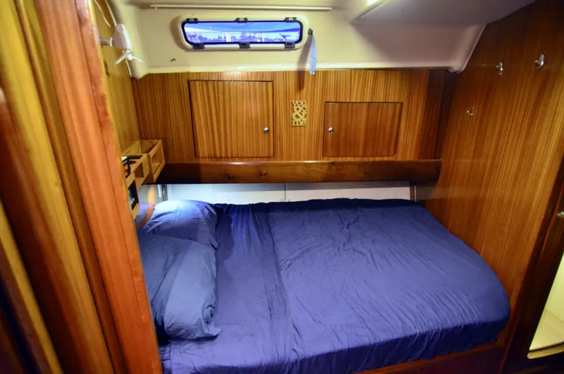 Footloose Yacht Photos Pics Cozy cabin interior of 2003 Bavaria 49 yacht with wooden paneling and blue bedding.