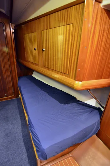 Footloose Yacht Photos Pics Interior cabin of 2003 Bavaria 49 yacht with wooden finish and blue bedding.