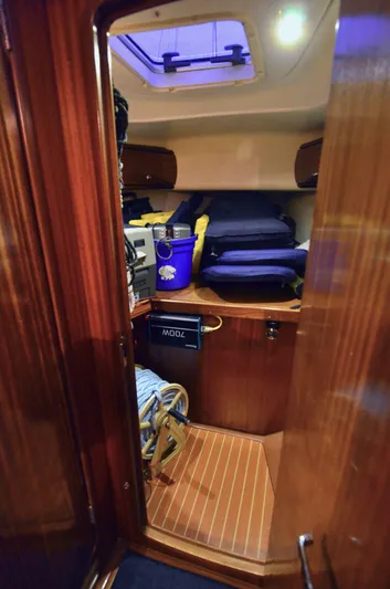 Footloose Yacht Photos Pics Interior cabin of a 2003 Bavaria 49 yacht with wooden finish and storage items.