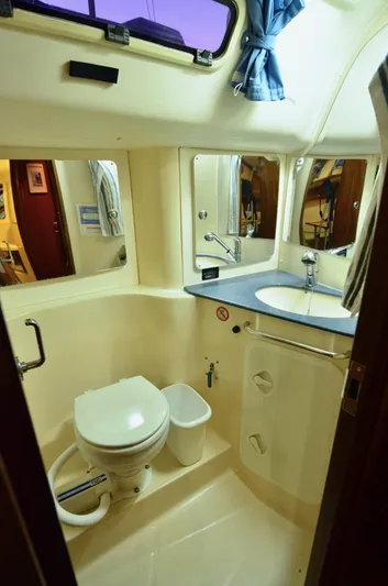 Footloose Yacht Photos Pics 2003 Bavaria 49 yacht bathroom with toilet, sink, mirror, and window.