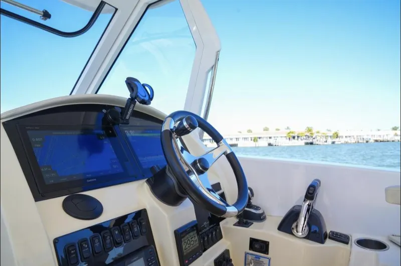  Yacht Photos Pics 2019 Regal 33 SAV boat cockpit with steering wheel and navigation screens.
