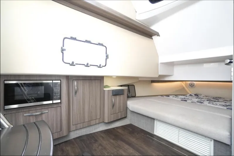  Yacht Photos Pics 2019 Regal 33 SAV interior with kitchenette and bed, featuring modern cabinetry and appliances.