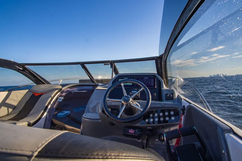 Ready For Delivery! Yacht Photos Pics Interior view of 2025 Hanover 305 Outboard boat, black and orange, on open water.