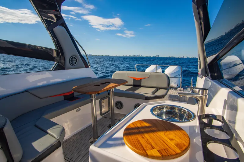 Ready For Delivery! Yacht Photos Pics Luxurious 2025 Hanover 305 Outboard boat interior with seating, table, and ocean view.
