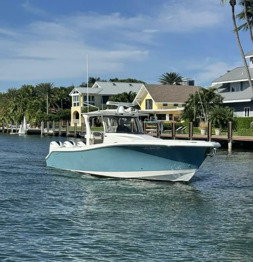  Yacht Photos Pics 2016 Edgewater 368 CC boat cruising near waterfront homes under a clear sky.